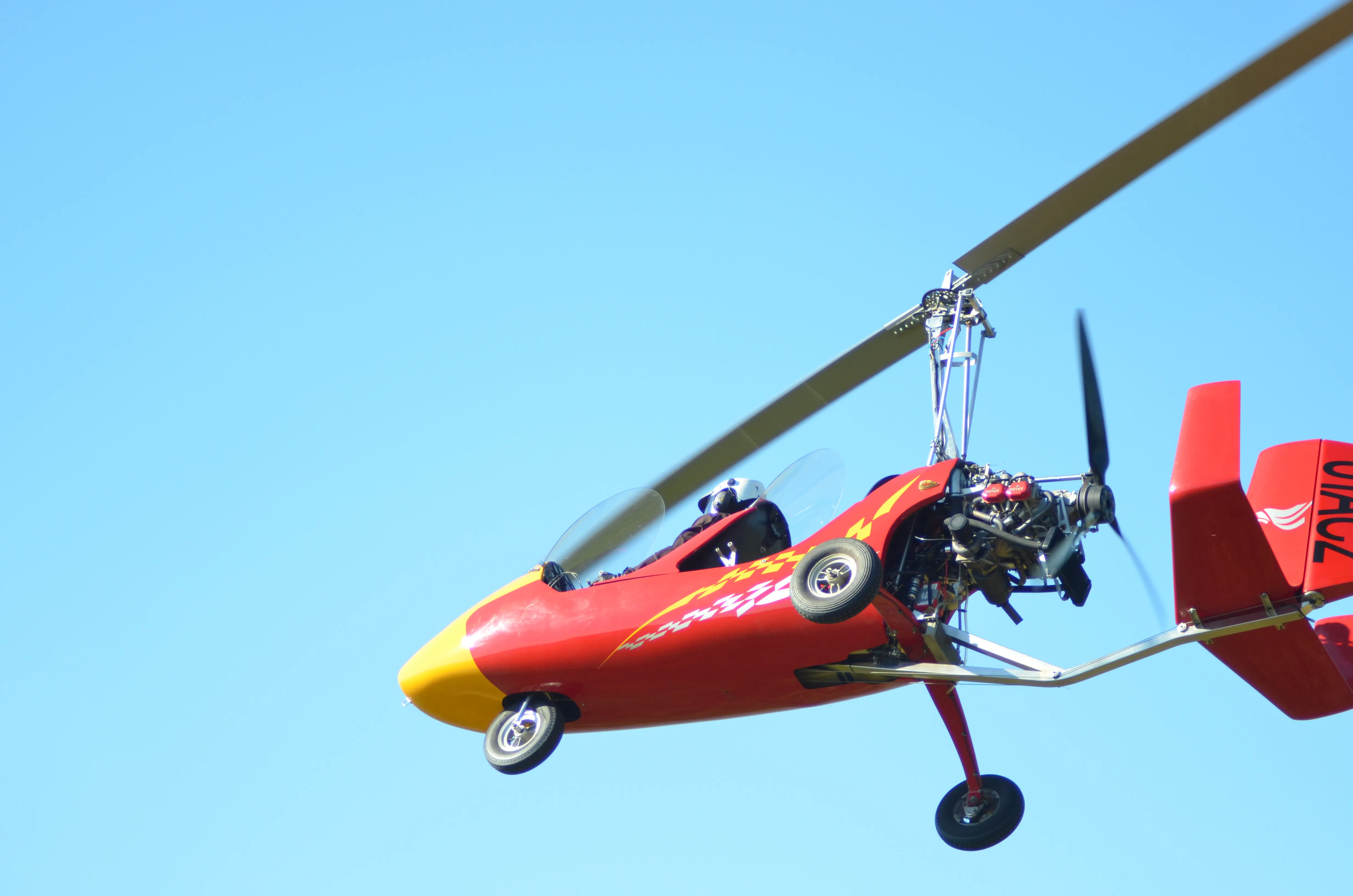 ULM autogire Autogyro MTOsport rouge et jaune en vol dans le ciel de Bretagne